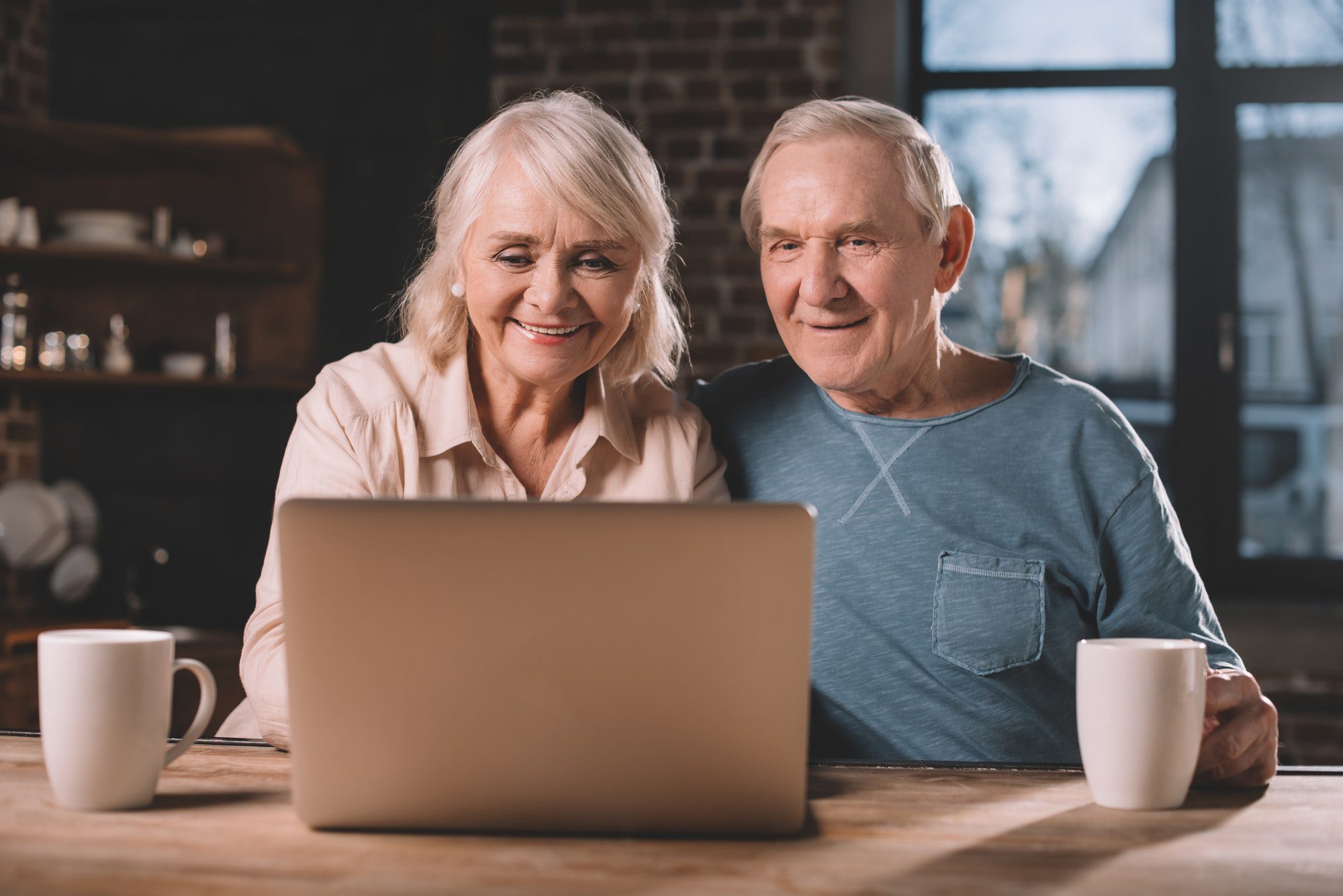 senior couple using laptop at home as they look up AARP Medicare Advantage Plans.