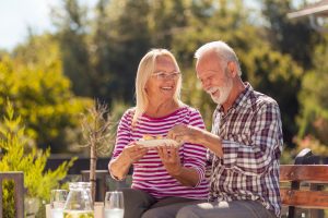 Senior couple eating breakfast outside happy with Medigap Plan C