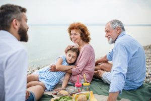 Multigeneration family on a holiday by the lake, having picnic with Medigap Plan G