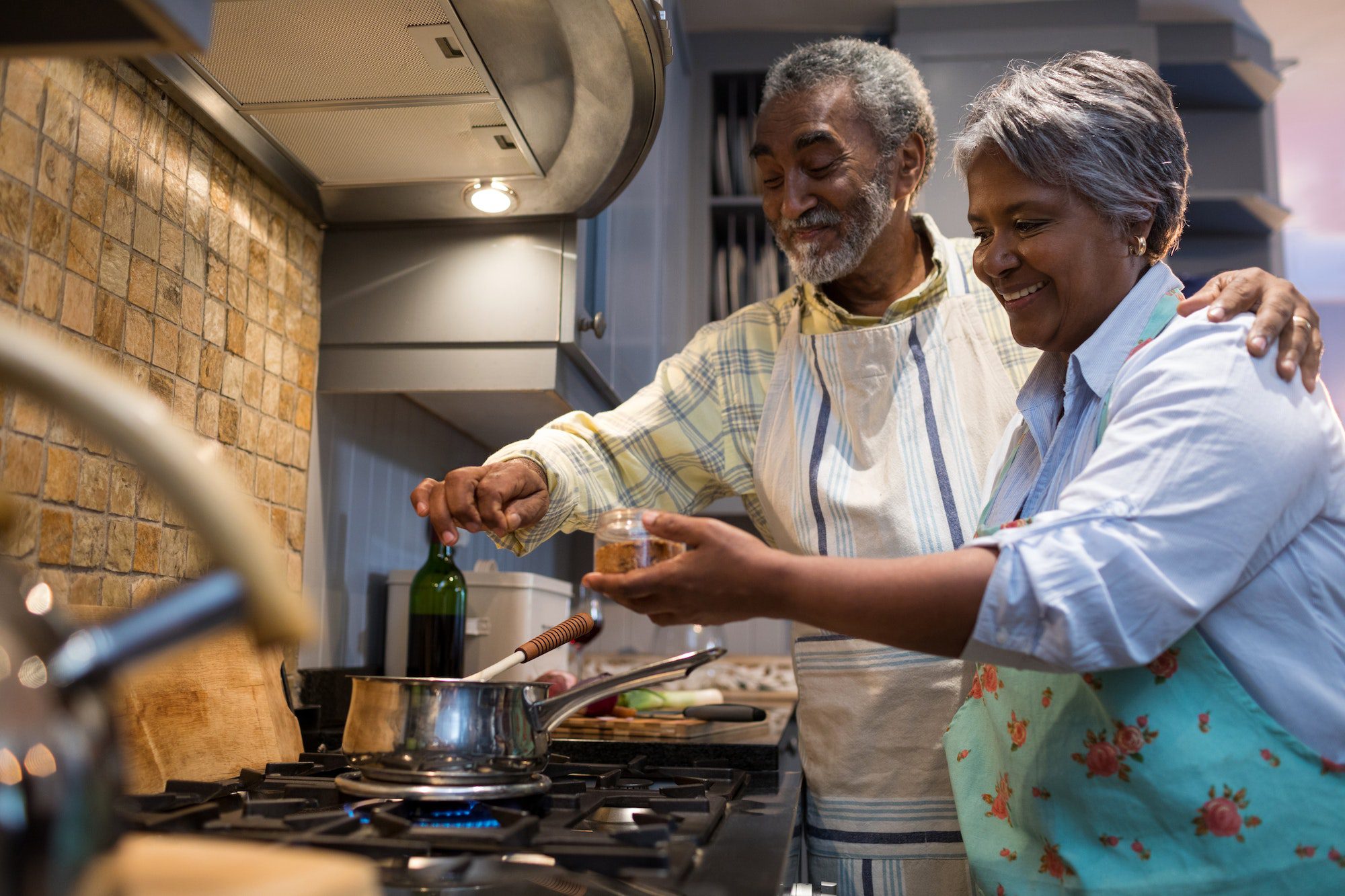 Smiling senior couple preparing food in kitchen ready for Annual Enrollment Period