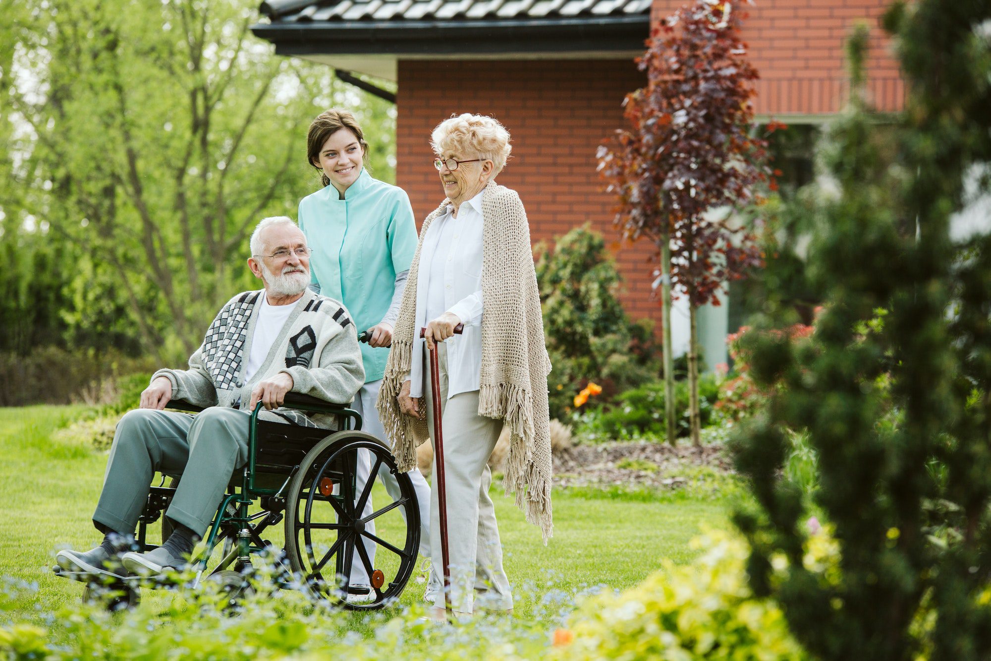 Senior man on the wheelchair in the garden of professional hospice care