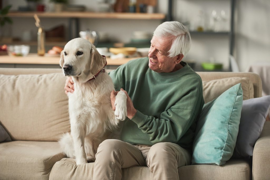 Senior man with dog at home with Medigap Plan F