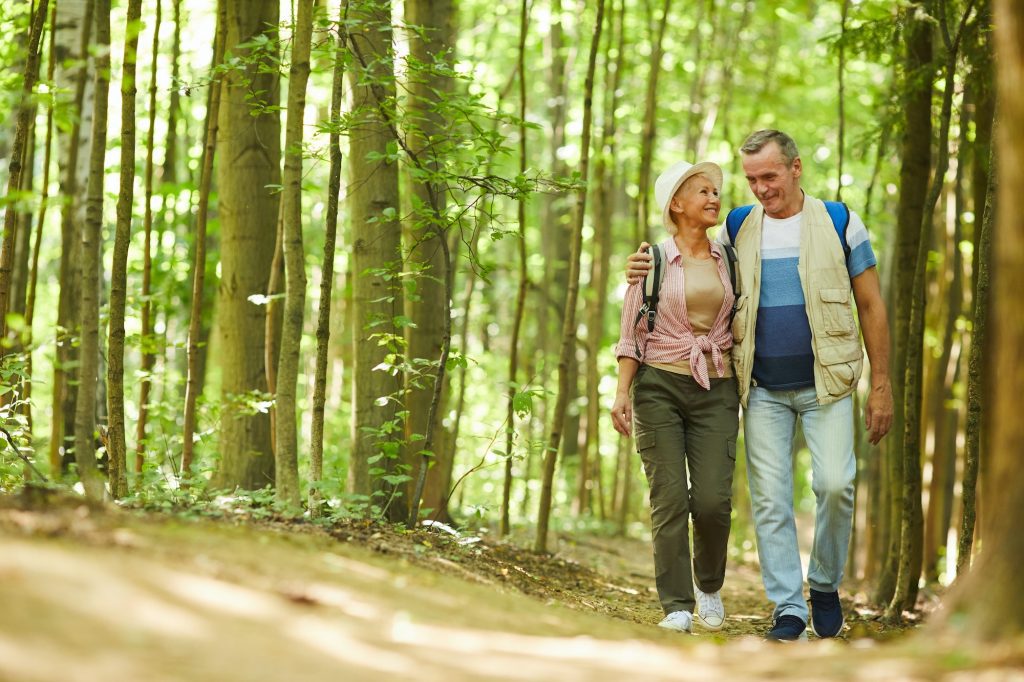 Senior couple walking in nature enrolled in Medicare