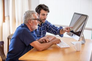 Man teaching Medicare beneficiary how to enroll in Medicare
