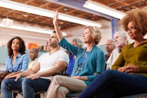 Woman raising hand to ask what Medicare Advantage plans are