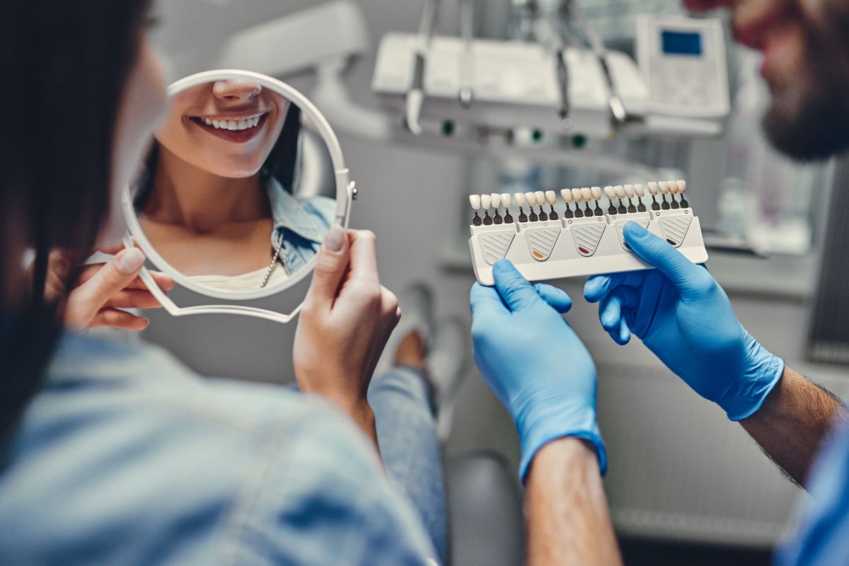 Person picking out a tooth shade for their dental treatment