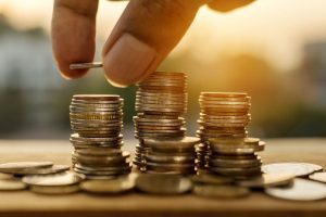 Person stacking coins to save money for healthcare costs