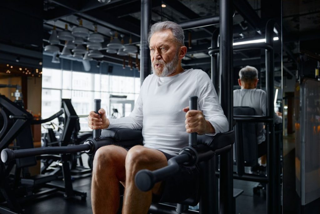 Medicare beneficiary doing workout routine at a gym