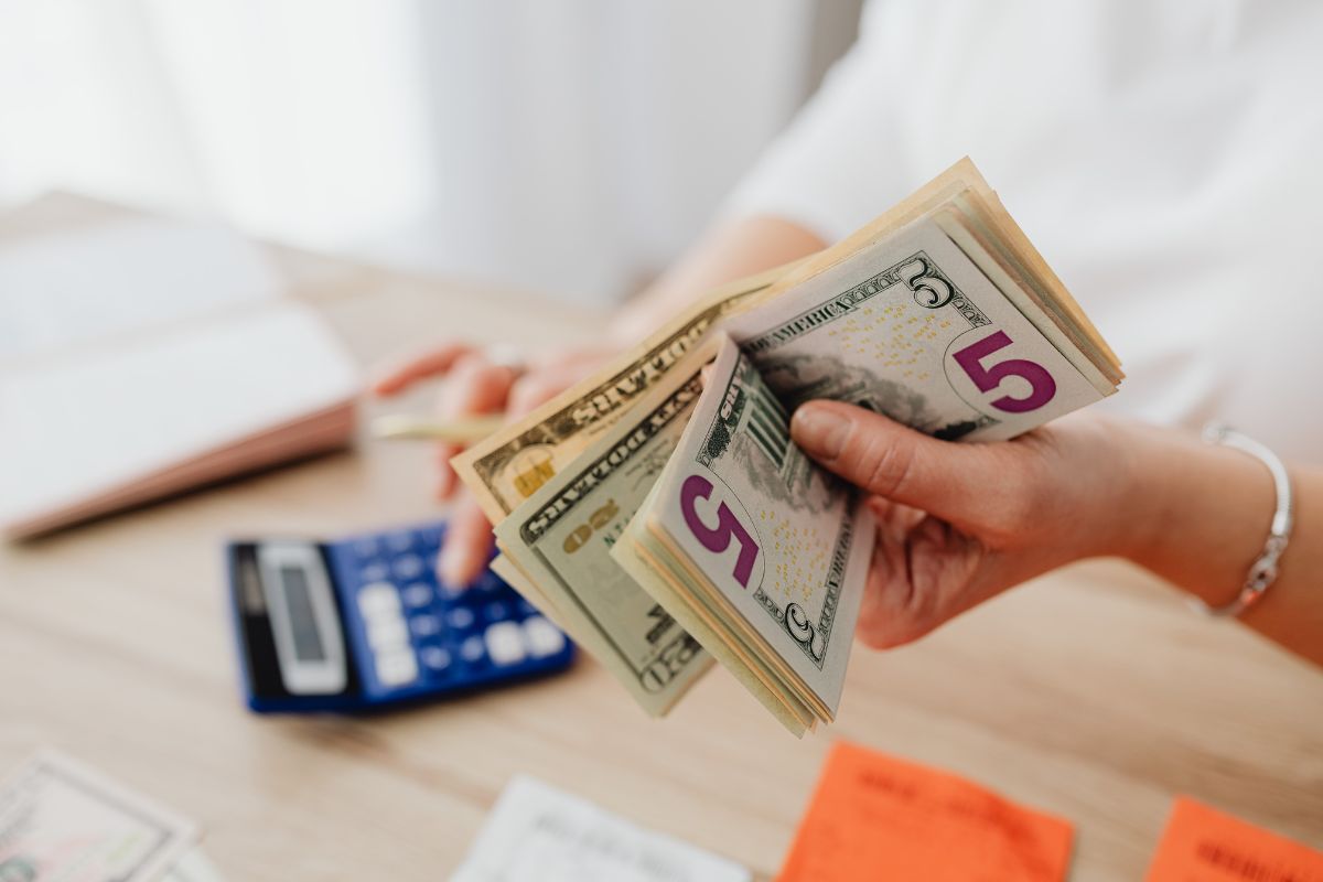 Person holding cash and calculating the increase Medicare costs